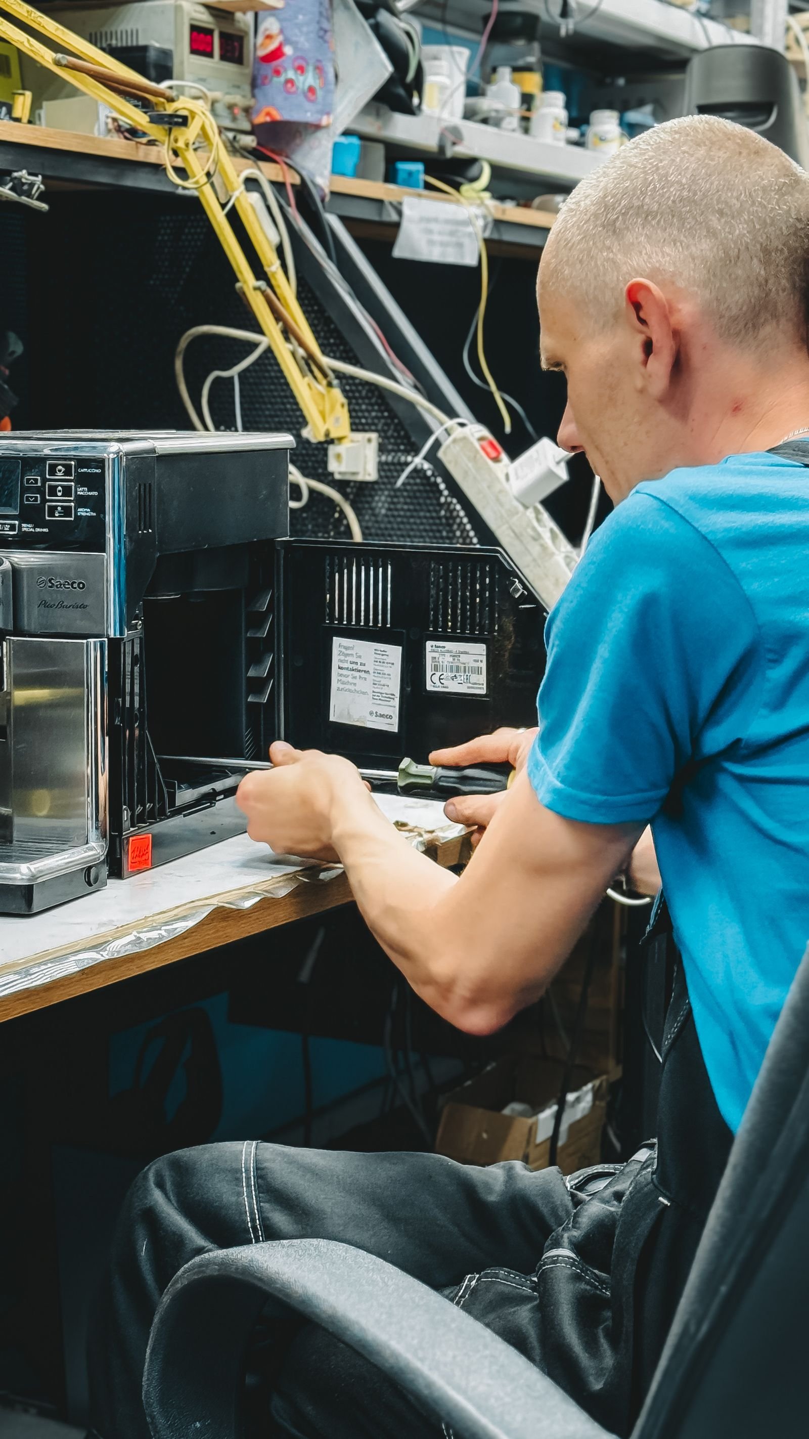 Technician repairing an electronic device in a workshop